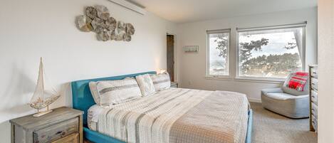Ein Schlafzimmer mit Bett, Nachttisch und einem Fenster mit Blick.