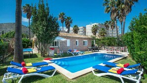 A swimming pool with lounge chairs and a small building in the background. - Villa Montelo with private pool near the sea (Alcúdia)