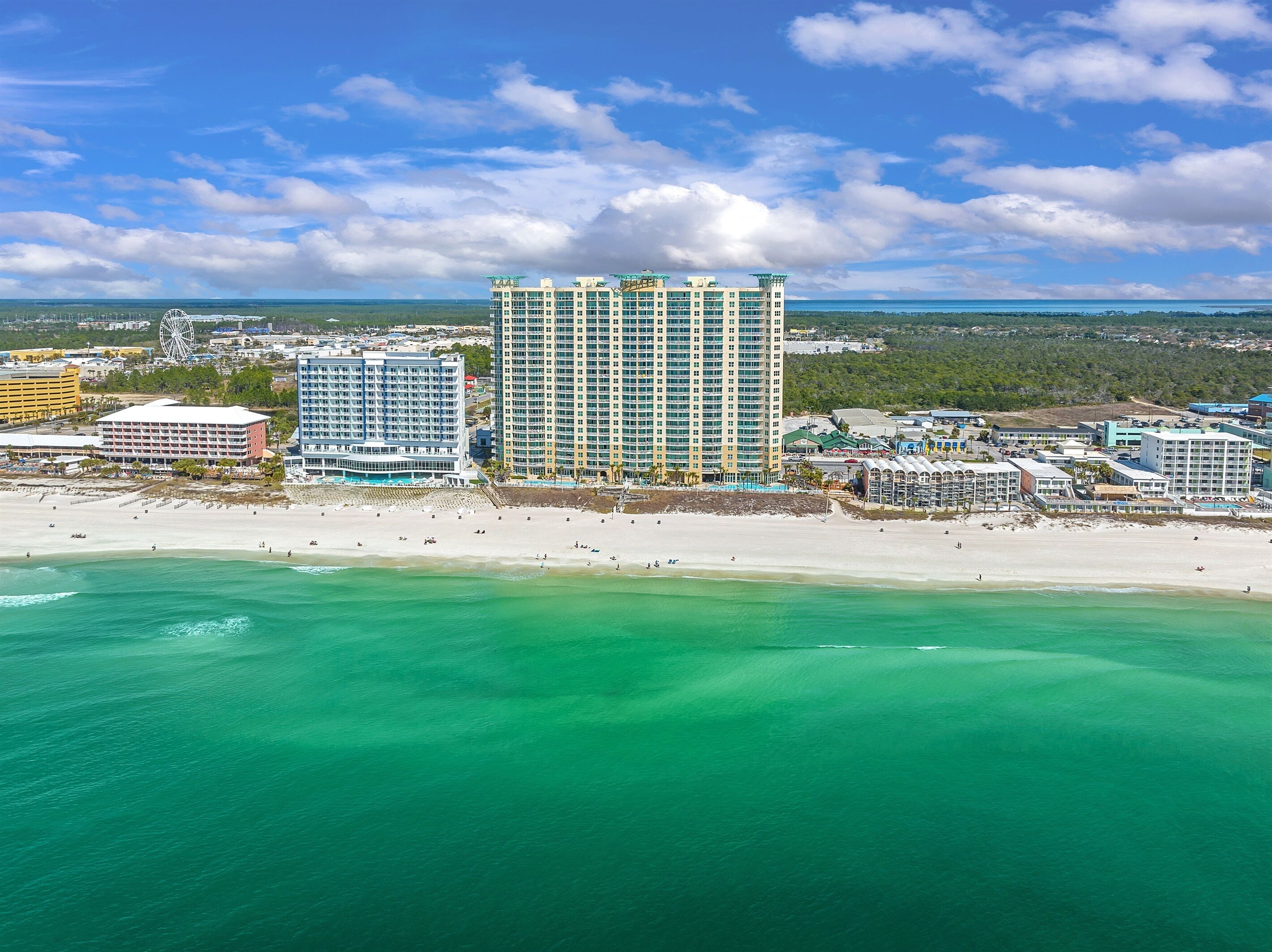 Un hotel costero con varios edificios altos, una playa y un cielo despejado.