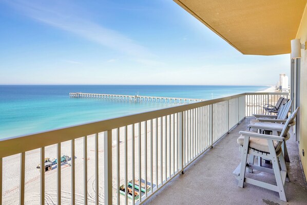 A balcony with a view of the ocean and a pier.