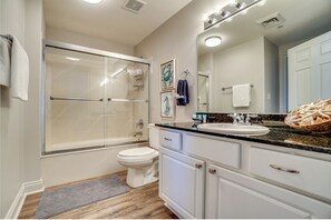 Een bad/douchecombinatie, een haardroger, handdoeken