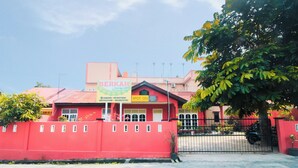 A red building with a sign that reads "BERKAH" and a "SPOT ON" sign. - SPOT ON 2370 Berkah Homestay Syariah (Pekanbaru)