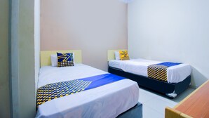 Two single beds with matching headboards and footboards, white bedding with blue and yellow patterns, and a wooden bench to the right. - SPOT ON 2370 Berkah Homestay Syariah (Pekanbaru)