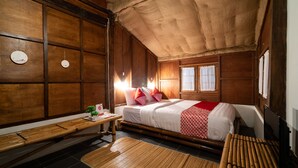 A traditional wooden room with a bed, a desk, and a window. - Hotel O Putroyono Homestay (Borobudur)