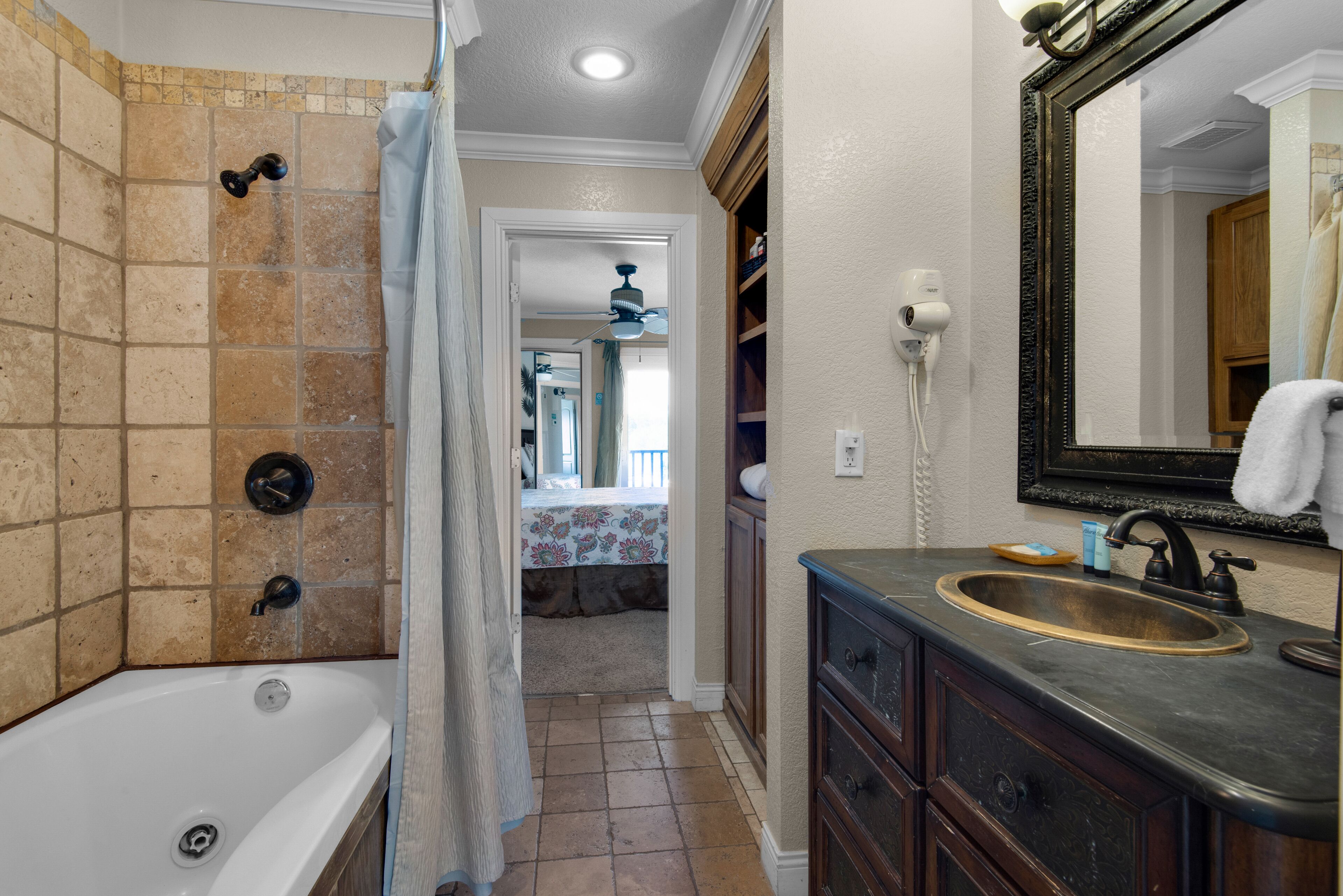 Une salle de bain avec une baignoire, une douche, un meuble-lavabo et un miroir.