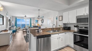 A modern kitchen with white cabinets, stainless steel appliances, and a view to the outside. - ⭐By Beach in Seascape-Gulf Views-2 Pools + Kids Fountain-3BR Ariel Dunes I 1609 (Miramar Beach)
