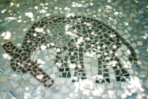 A mosaic floor with a circular pattern. - George Apartments (Tilos)