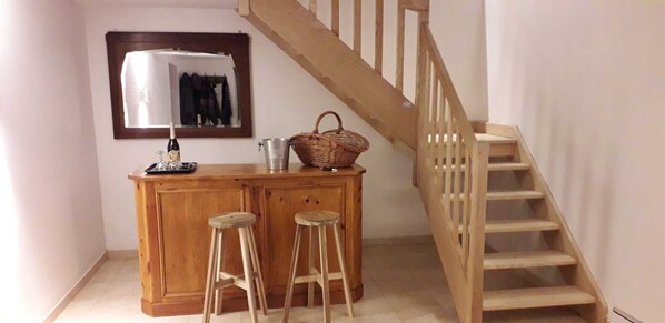 A wooden bar area with stools, a basket, and a bottle on a counter. - COMPLETE AUTHENTIC QUIET & HEALTHY HOUSE WITH PICINE 10x4m = 100% YOURS (Saint-Martial)