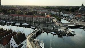 A harbor with boats docked, a bridge, and buildings with red roofs. - Middelburg4you (Middelburg)