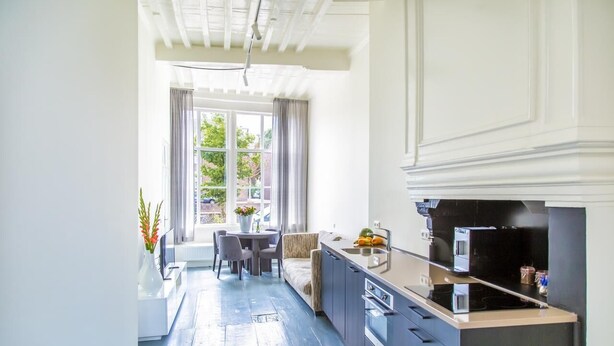 A modern kitchen with a dining area, large windows, and a view of greenery outside. - Middelburg4you (Middelburg)