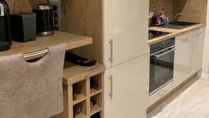Eine moderne Küche mit Holzausstattung, einem eingebauten Backofen und einer Arbeitsplatte mit Toaster und Kaffeemaschine.