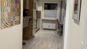 Eine moderne Küche mit Kochinsel, integrierten Geräten und einem großen Fenster.