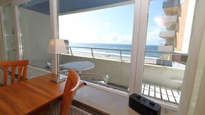 A balcony with a table and chairs, a lamp, and a view of the beach and ocean. - Haus am Meer14-app 091 WB (Sylt)