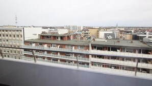 A view of a cityscape from a high vantage point, featuring multiple buildings with flat roofs and a mix of architectural styles.