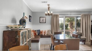 A dining area with a wooden cabinet, a table, chairs, and a chandelier.