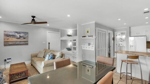 A modern kitchen with white cabinets, a built-in oven, and a stainless steel refrigerator.