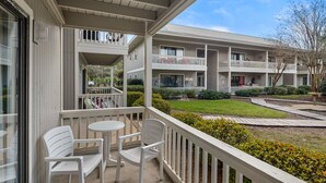 Un hôtel à plusieurs étages doté de balcons, d’un espace extérieur aménagé pour s’asseoir et d’un jardin bien entretenu.