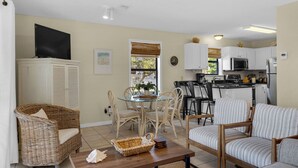 A compact living space with a dining area, kitchen, and seating arrangements. - Mins to Beach, 2 Pools & Tennis, Ground Floor Unit + Free Attraction Tickets! (Santa Rosa Beach)