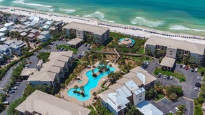 A resort with a swimming pool, beachfront, and multiple buildings. - 1st Floor, Gulf Side, Lagoon Pool, Beach Chair + Free Attraction Tickets! (Panama City Beach)