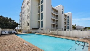 A swimming pool area with lounge chairs and a building with balconies. - Gulf-Front & Amazing Views in this Updated Condo + Free Attraction Tickets! (Santa Rosa Beach)