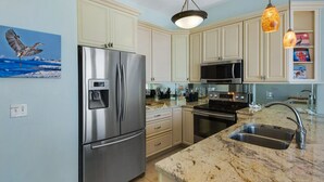 A modern kitchen with stainless steel appliances, a marble countertop, and light-colored cabinetry. - Gulf Front in Seagrove ~ Amazing Views + Free Attraction Tickets! (Santa Rosa Beach)