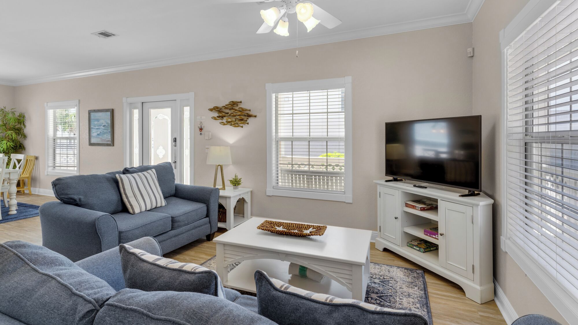 A living room with a grey sofa, a coffee table, a TV on a stand, and a bookshelf.