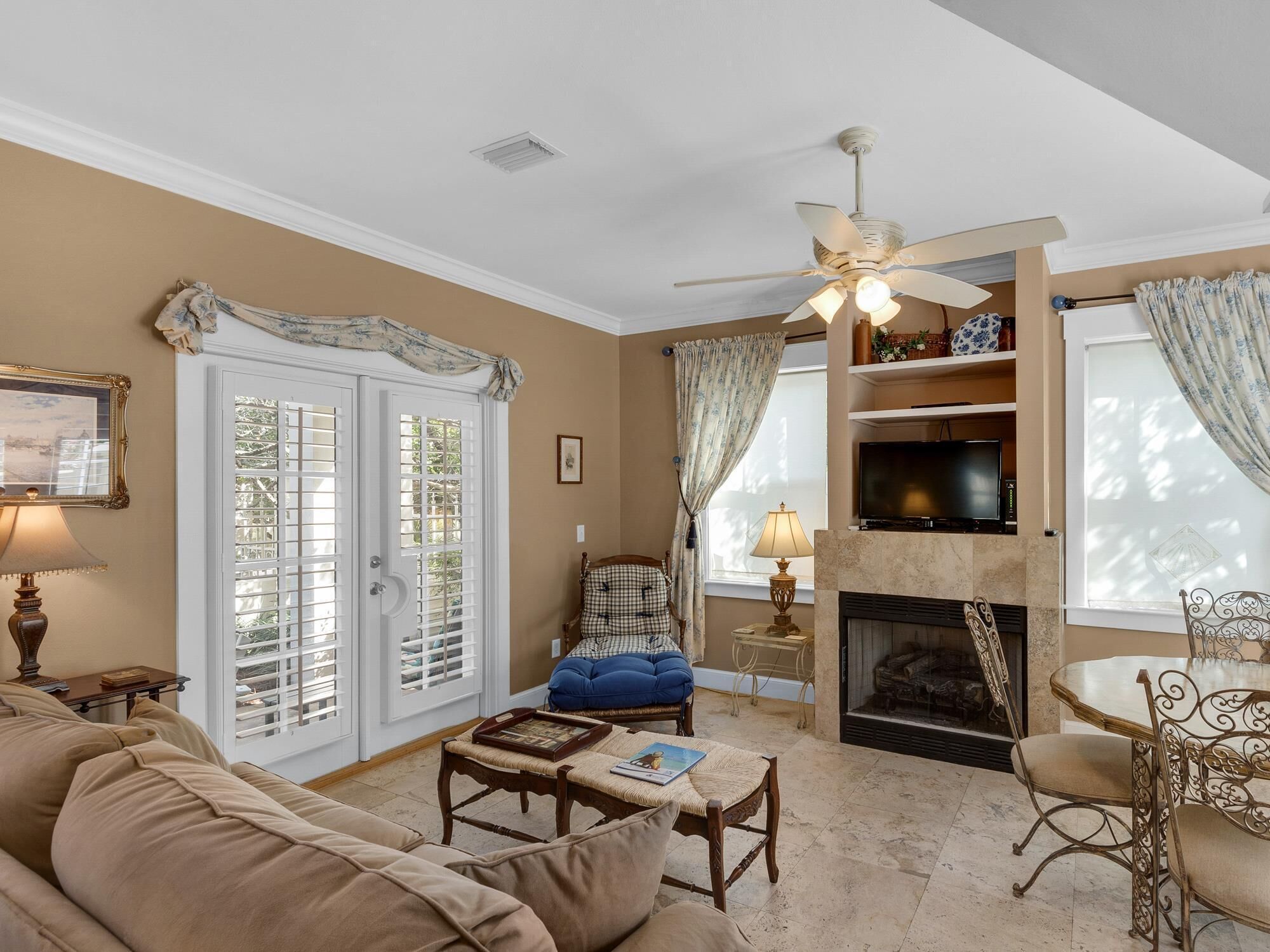 A living room with a beige sofa, a coffee table, a fireplace, and a television.