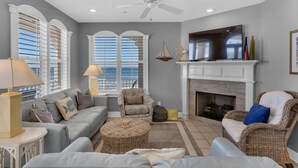A living room with a fireplace, a sofa, a chair, and a lamp.
