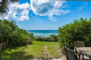 A pathway leading to a beach with a clear view of the ocean, surrounded by lush greenery. - Gulf Front - Seagrove Beach + Free Attraction Tickets! (Santa Rosa Beach)