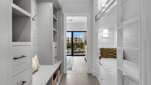 A narrow hallway with white walls and a balcony with a view of buildings.
