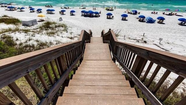 A wooden staircase leading to a beach with umbrellas and people. - Seagrove Beach | Gulf Side + Free Tickets: Bikes, Dolphin Cruise & More! (Santa Rosa Beach)