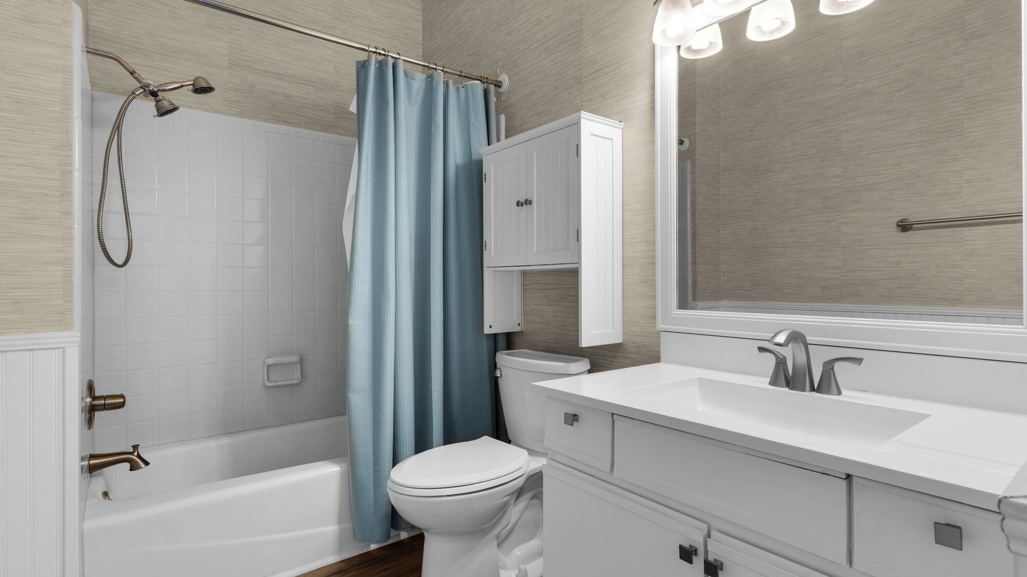 A modern bathroom with a bathtub, toilet, and vanity with a mirror.