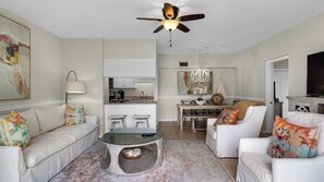 A living room with a sofa, chairs, a coffee table, and a dining area with a table and chairs.