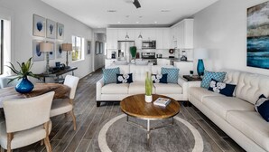 Uma sala de estar moderna com sofá, mesa de centro e área de refeições.