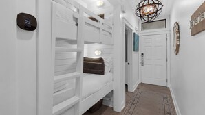 A hallway with white built-in benches, a digital thermostat, and a door with a light fixture above it. - Modern 1st-Floor Condo with Gulf Views + Free Attraction Tickets! (Santa Rosa Beach)