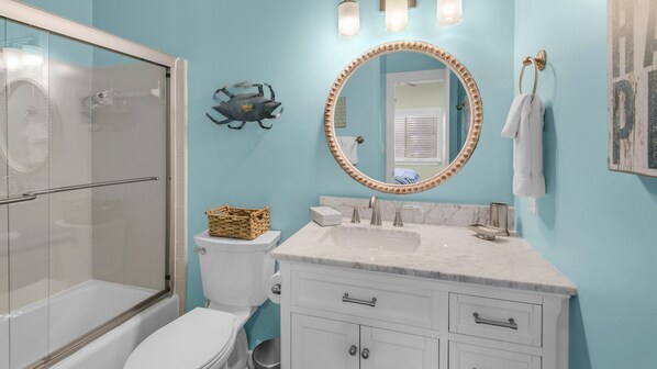 A bathroom with a glass shower enclosure, a toilet, a sink with a marble countertop, and a vanity with cabinets. - Updated Gulf Front in Seagrove, Direct Sunset View + Free Attraction Tickets! (Santa Rosa Beach)