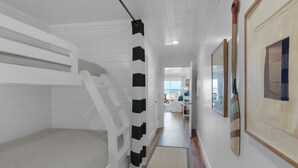 A hallway with a bunk bed, a wooden ladder, and a door leading to a balcony with a view of the beach. - Direct Gulf views & access to the sparkling waters + Free Attraction Tickets! (Santa Rosa Beach)