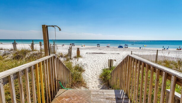A wooden boardwalk leading to a sandy beach with umbrellas and people in the distance. - Direct Gulf views & access to the sparkling waters + Free Attraction Tickets! (Santa Rosa Beach)