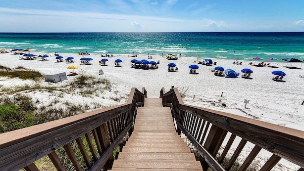 A wooden staircase leading to a beach with white sand and blue umbrellas. - Gulf-Front, Pool in Seagrove, Next Door to Seaside + Free Attraction Tickets! (Santa Rosa Beach)