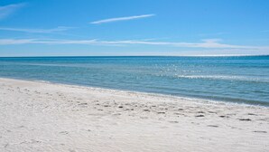 A beach with clear blue water and a sandy shore. - Dog-Friendly Gulf Side Cottage, 6 Mins to Beach, Pool, Bikes + Free Tickets! (Santa Rosa Beach)