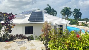 A house with solar panels, a swimming pool, and tropical plants. - Shell House, Dominican Caracol with 14m Pool and Ocean view (Cabrera Maria Trinidad Sanchez)