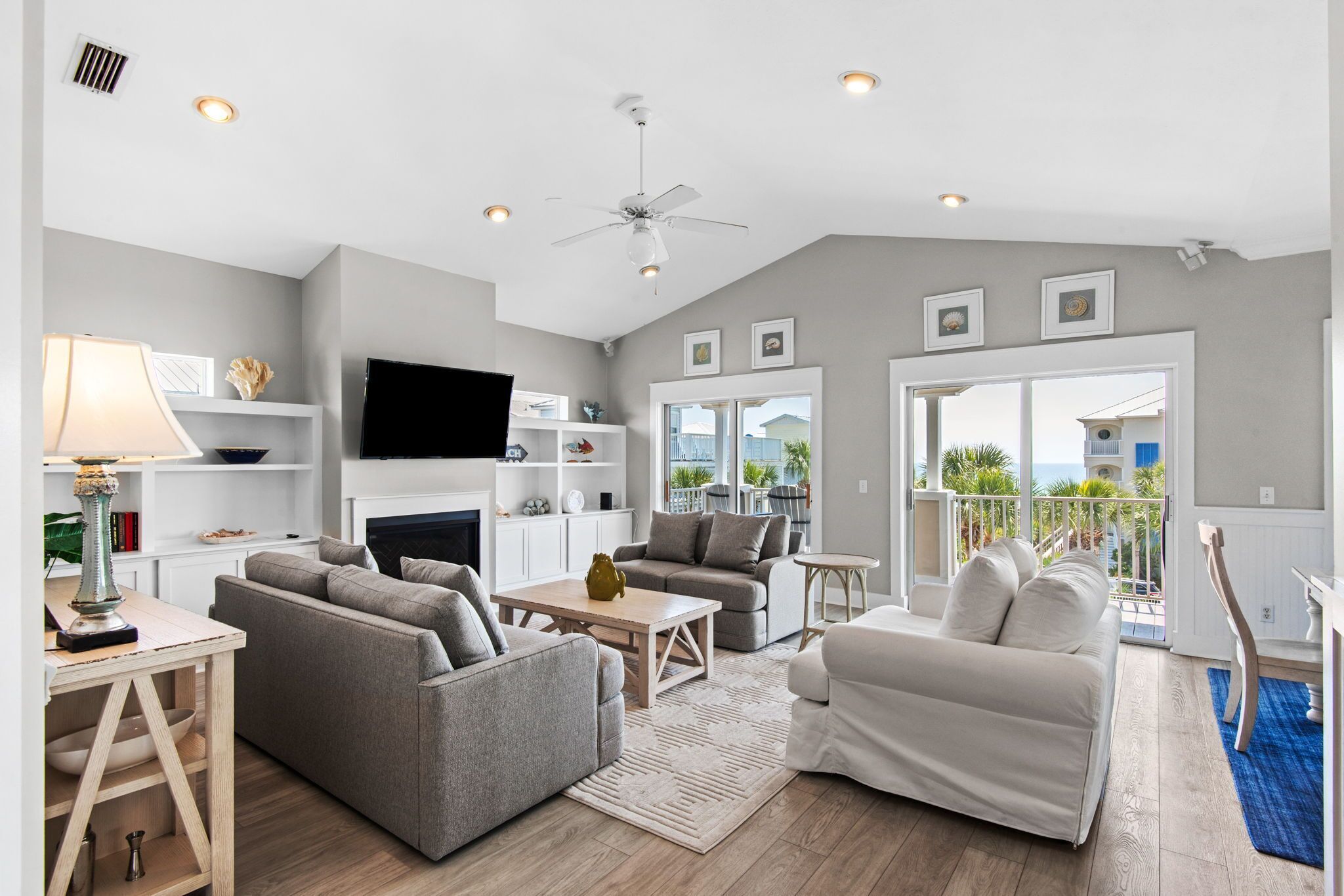 A modern living room with a fireplace, sofas, a coffee table, and a TV.