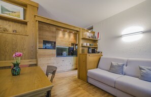 A compact living space with a kitchenette, a dining area, and a seating area.