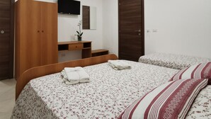 A bedroom with a bed, a wooden wardrobe, a TV, and a mirror. - Villa Antonio (Aci Castello)