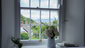 A room with a large window offering a view of a green landscape and the sea. - NEW 2021, Idyllic Cottage in Polkerris,  by the beach, sea views, near Fowey. (Par)