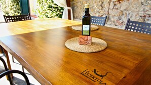 Una mesa de madera con una botella de vino y un posavasos, con el logotipo de "La Lucertola".