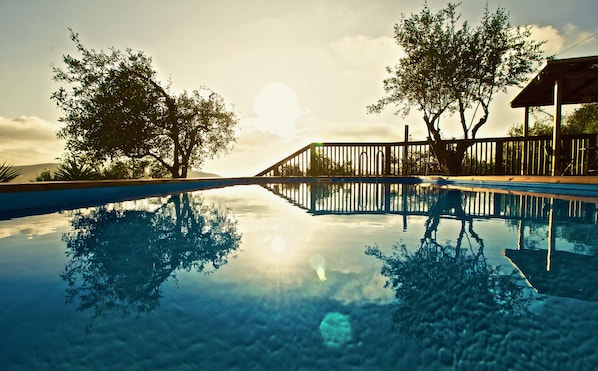 Alberca al aire libre y camastros 