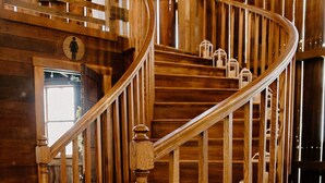 Un escalier en colimaçon en bois, doté d’une main courante et de marches.