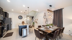 A modern kitchen with a built-in oven and a dining area with a wooden table and chairs.