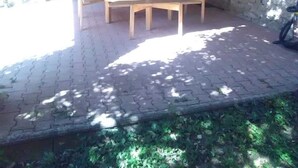 An outdoor patio with wooden tables and benches, a stone wall, and a rustic wooden ceiling. - abundance, Stone house with land of 2000m2 at the foot of the vercors (La Baume-Cornillane)
